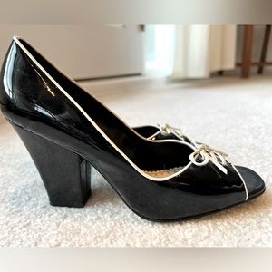 Black patent leather shoes with white trim and bow.